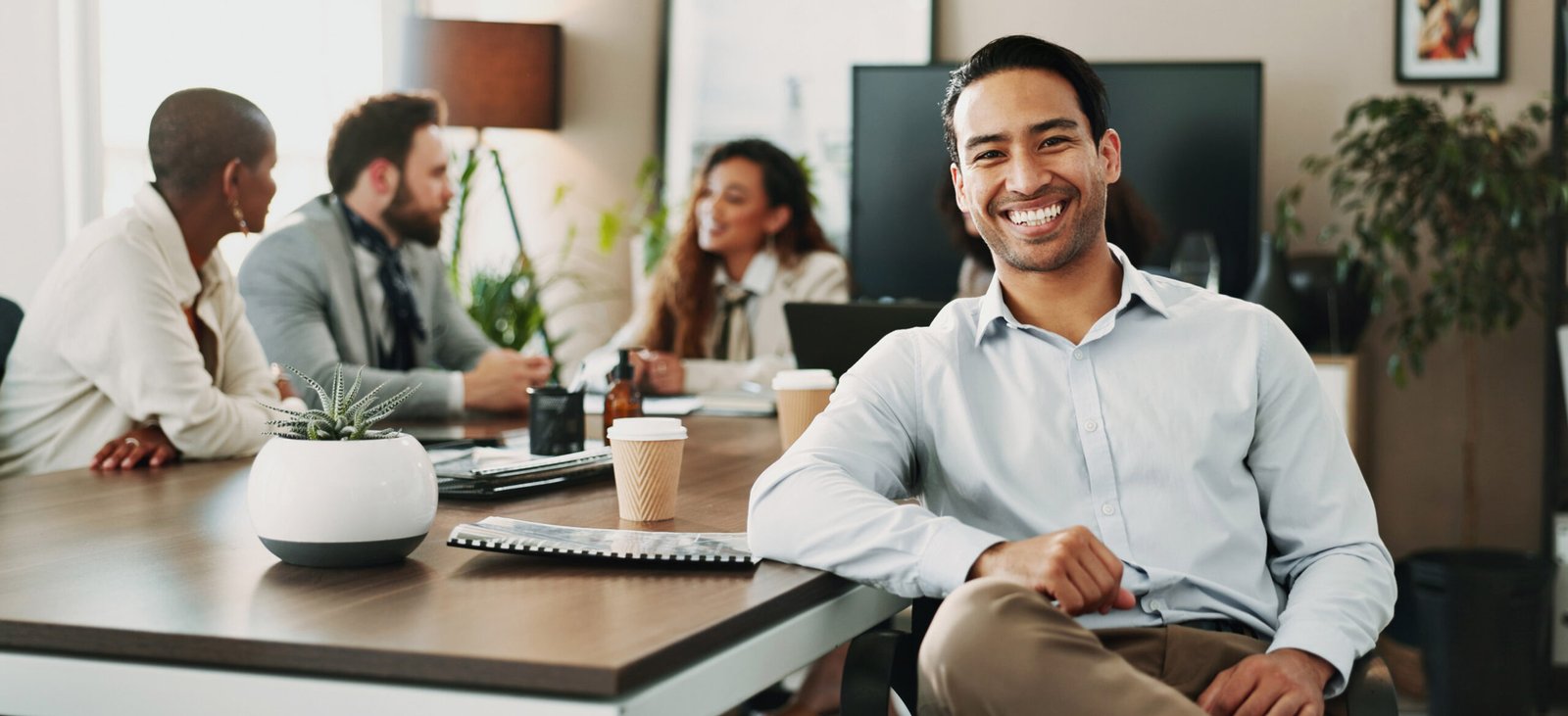 A man smiling at a boardroom table