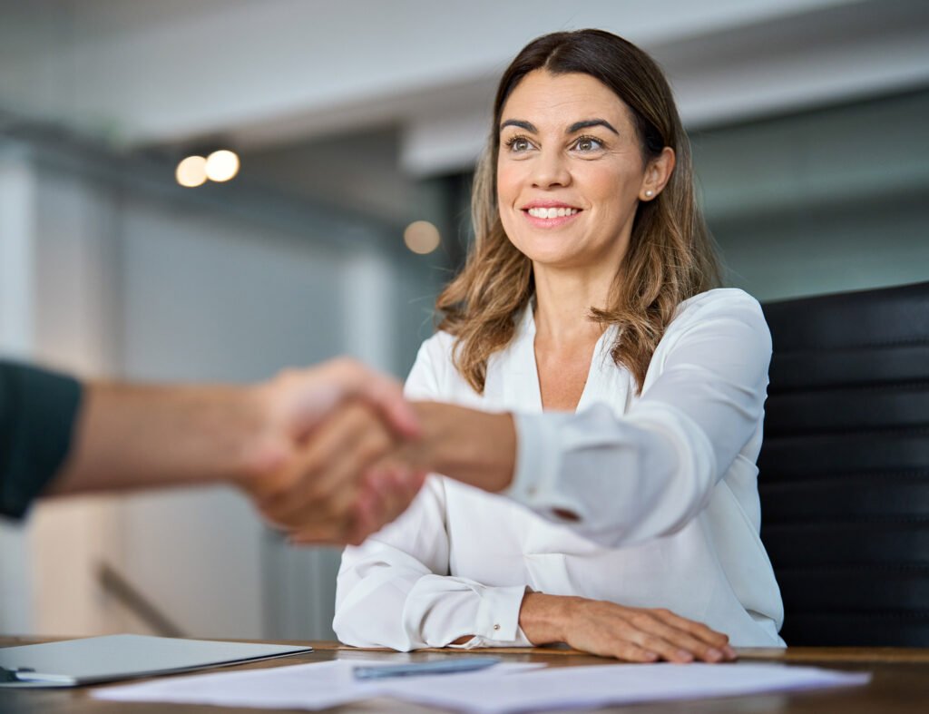 An employer shaking the hand of a new employee