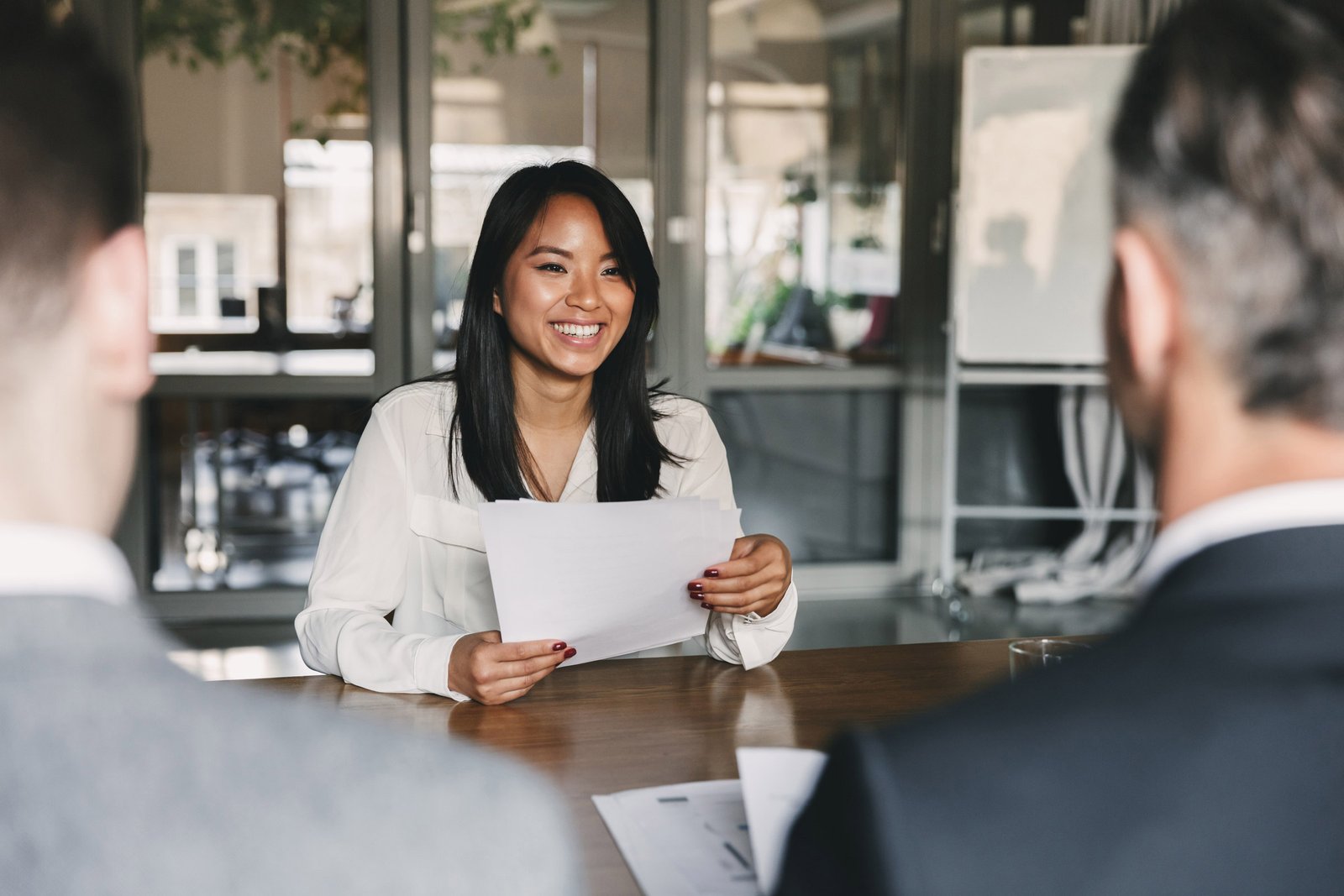 A future employee sits at a meeting table with their resume