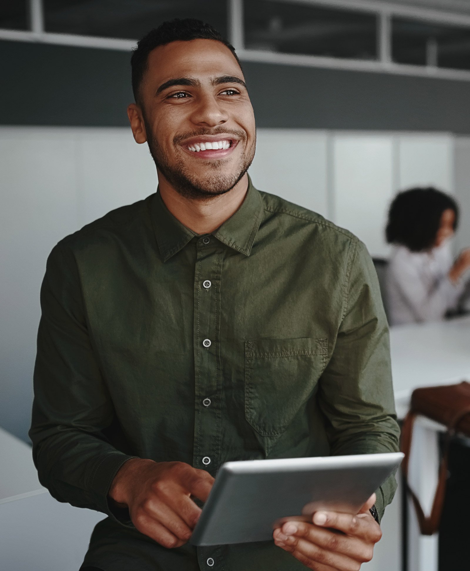 An employee standing smiling with a tablet