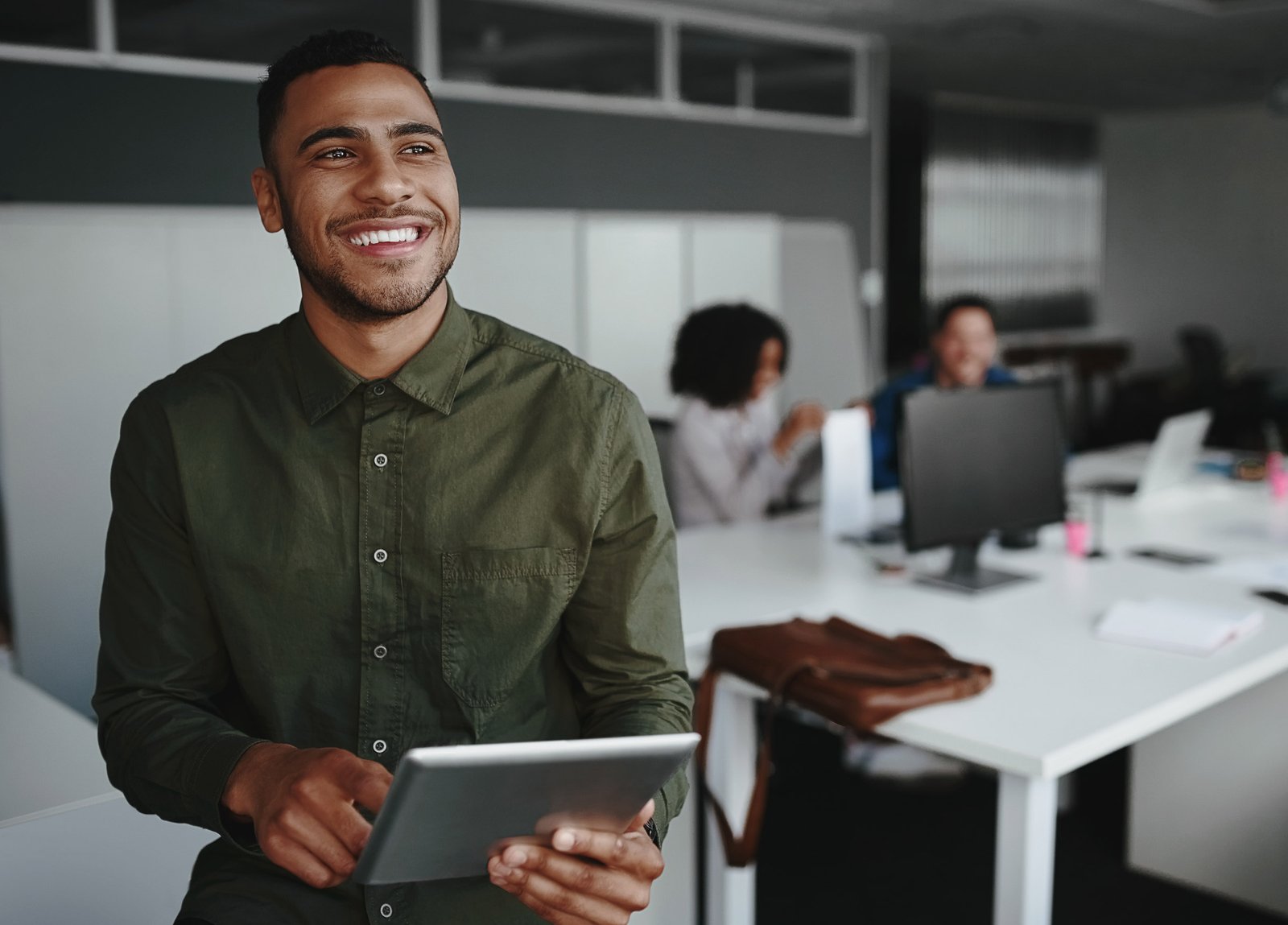 An employee standing smiling with a tablet