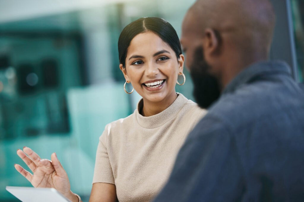 Two coworkers chatting and smiling