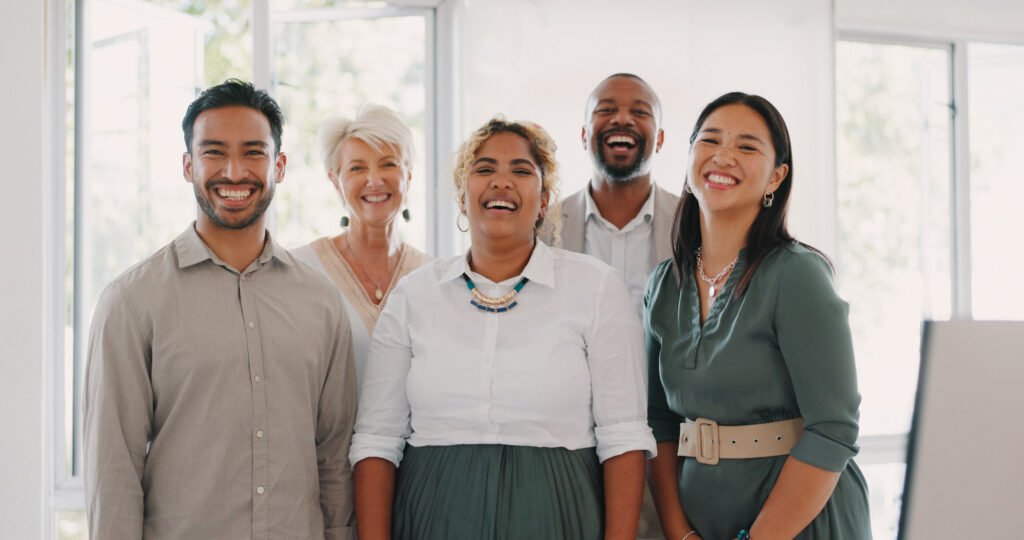 A group of diverse workers standing together smiling
