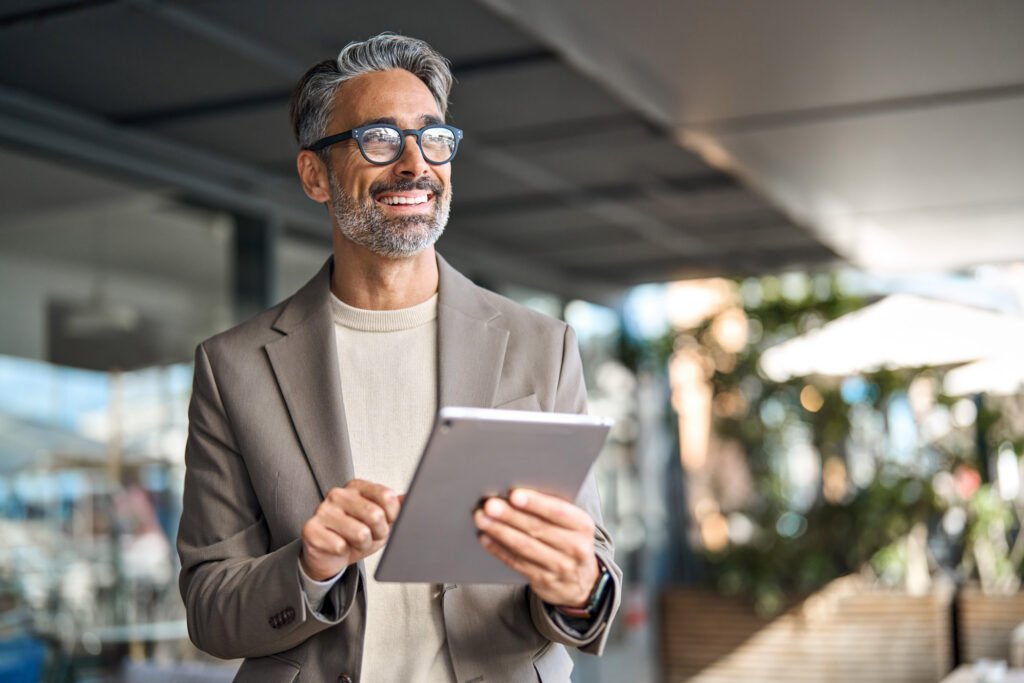 An employer holding a tablet smiling in the office