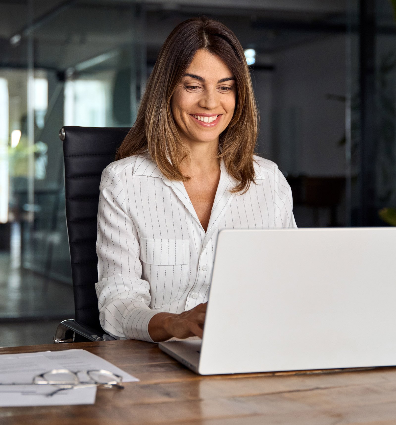 A smiling business professional on their laptop