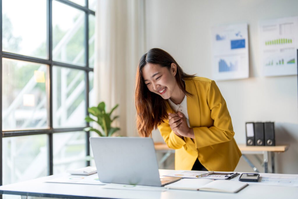 An employee bowing over their laptop in thanks