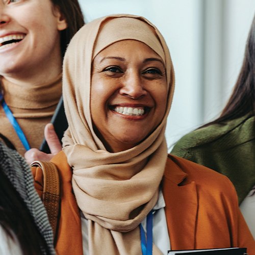 An employee smiling in a conference crowd