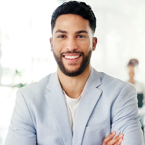 An employee smiling with their arms crossed