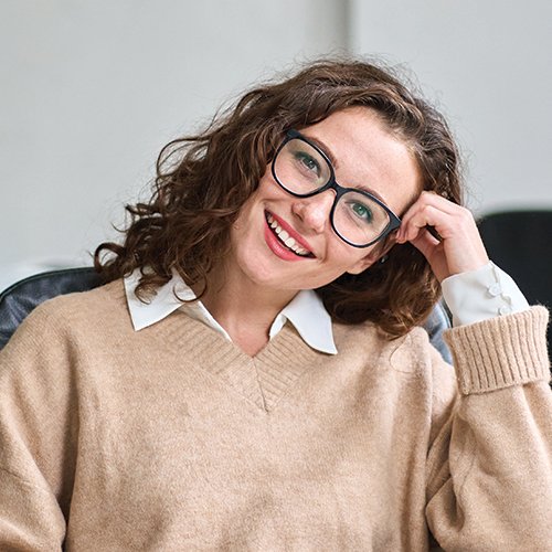 A women smiling with her head in her hands